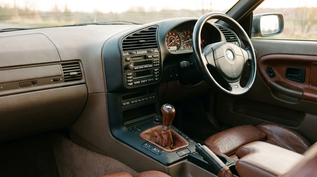 Intérieur typique de la BMW E36 avec tableau de bord orienté vers le conducteur.
