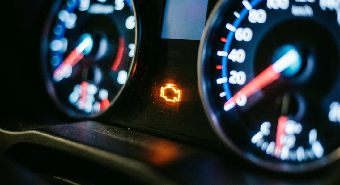 Voyant moteur allumé sur le tableau de bord d'une voiture.